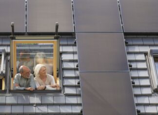 Energy Sharing: Solarstrom lokal teilen wird ab Juni 2026 möglich Foto zeigt ein Paar am Dachfenster mit Blick auf die PV-Anlage